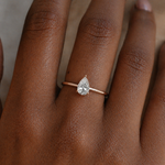 Load image into Gallery viewer, Lab grown pear cut diamond hidden halo engagement ring worn on a hand in 18K rose gold