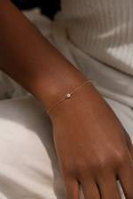 Load image into Gallery viewer, Round bezel natural diamond bracelet worn on a woman’s wrist.