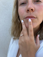 Load image into Gallery viewer, Emerald cut lab-grown diamond ring with tapered side stones worn on hand in yellow gold