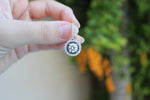Load image into Gallery viewer, Hand holding hanging double halo natural diamond earring in white gold, black and white halo diamonds, outdoor lighting