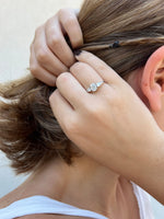 Load image into Gallery viewer, three stone oval diamond engagement ring with pear side stones worn on hand