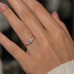 Load image into Gallery viewer, Three stone lab-grown diamond ring worn on hand with round center and pear side stones