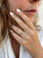 Load image into Gallery viewer, Natural emerald cut diamond ring with tapered side stones in yellow gold ā lifestyle hand view
