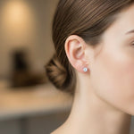 Load image into Gallery viewer, Round natural diamond stud earring worn on ear, classic solitaire setting with a single brilliant-cut diamond, minimalist fine jewelry close-up.
