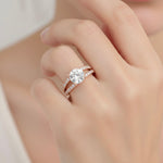 Load image into Gallery viewer, Round cut lab grown diamond engagement ring with a split shank design, set in rose gold, shown on a woman’s hand.