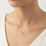 Load image into Gallery viewer, Round solitaire lab-grown diamond necklace in yellow gold on the neck of a woman, front view