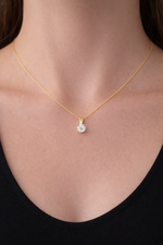 Load image into Gallery viewer, Round lab-grown diamond solitaire pendant necklace in yellow gold on a woman’s neck, delicate thin gold chain, close-up jewelry photo