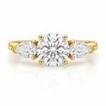 Load image into Gallery viewer, Three stone lab-grown diamond engagement ring with a round center diamond and pear side diamonds in yellow gold on a white background.
