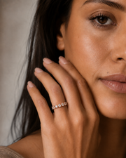 Five-stone natural diamond band in white gold shown on a woman’s hand.