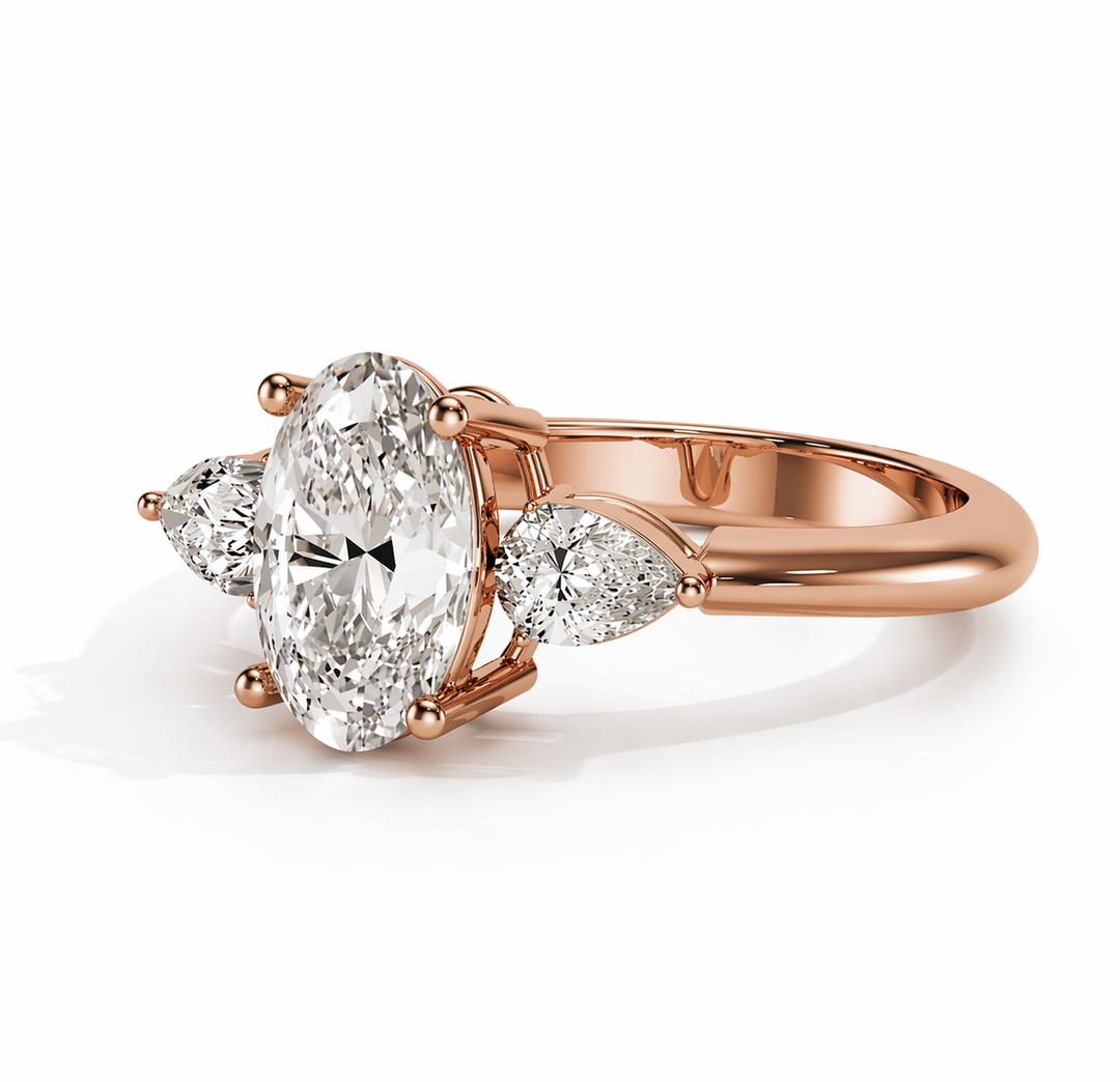     Rose gold lab-grown oval diamond ring with pear side stones, perspective view highlighting the three stone design