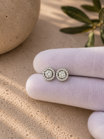 Load image into Gallery viewer, Round Lab-Grown Diamond Stud Earrings with Detachable Halo Jackets in White Gold displayed on a white jewelry glove in a natural lifestyle setting.