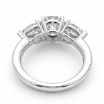 Load image into Gallery viewer, Underside view of a three stone lab-grown diamond engagement ring in white gold with a round center diamond and pear side diamonds.
