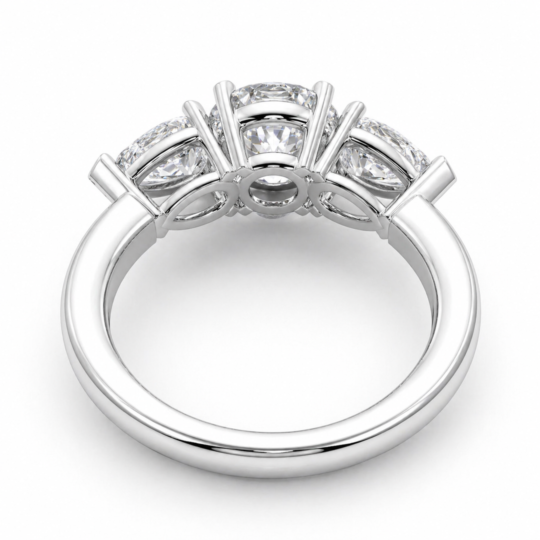 Underside view of a three stone lab-grown diamond engagement ring in white gold with a round center diamond and pear side diamonds.