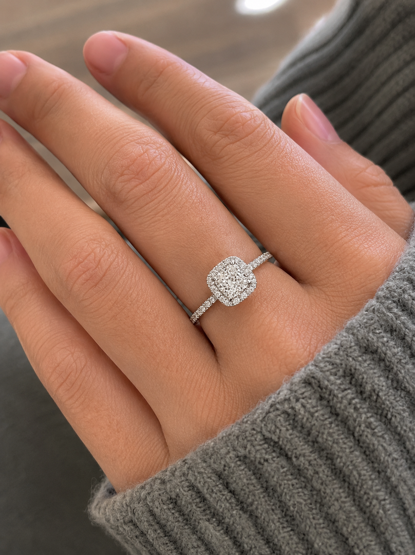     Close-up of a cushion halo lab-grown diamond ring worn on a woman’s hand.