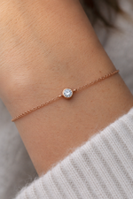 Load image into Gallery viewer,     Round bezel lab-grown diamond bracelet worn on a woman’s wrist.