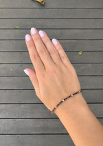 Load image into Gallery viewer, Natural Black &amp; White Diamond Tennis Bracelet in White Gold Worn on a Woman’s Wrist, Showcasing Alternating Round Black and White Diamonds in an Elegant Tennis Bracelet Style.