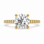     Round solitaire natural diamond ring with pavé side diamonds in yellow gold.