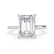 an emerald cut diamond ring on a white background