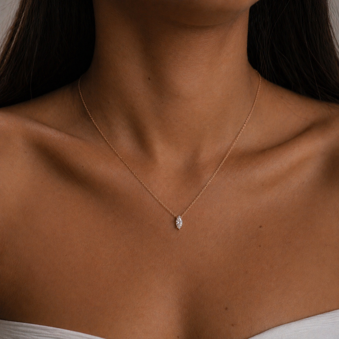 Woman wearing a marquise lab-grown diamond solitaire pendant necklace in 14K rose gold styled as an everyday minimalist necklace.