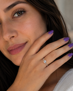 Load image into Gallery viewer, Woman wearing a lab-grown cushion-cut solitaire engagement ring with pavé diamonds along the band.