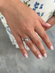 a woman's hand with a diamond ring on it