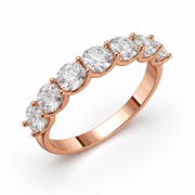 Seven stone round natural diamond half eternity band in rose gold, angled view on a white background.