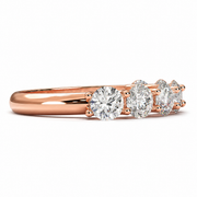 Side view of a seven stone round lab-grown diamond half eternity band in rose gold on a white background.