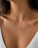 Load image into Gallery viewer, Round solitaire lab-grown diamond necklace in yellow gold on the neck of a woman, front view