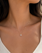 Load image into Gallery viewer, Natural round diamond V-bale solitaire pendant necklace in yellow gold displayed on a woman’s neck