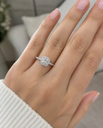 Load image into Gallery viewer,     Close-up of a cushion halo natural diamond ring worn on a woman’s hand.