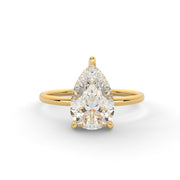 a yellow gold ring with a pear shaped diamond