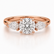 Three stone lab-grown diamond engagement ring with a round center diamond and pear side diamonds in rose gold on a white background.