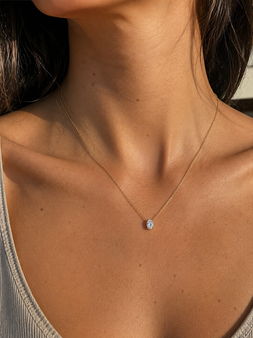     Oval lab-grown diamond pendant necklace in yellow gold, shown on a woman’s neckline with a delicate chain.