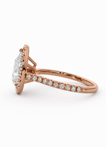 Load image into Gallery viewer, Side view of a natural pear halo diamond ring in 14K rose gold with a pavé diamond band.