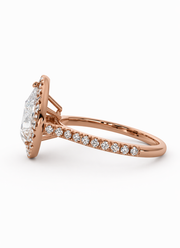 Side view of a natural pear halo diamond ring in 14K rose gold with a pavé diamond band.