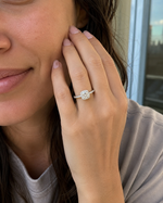 Load image into Gallery viewer,     Woman wearing a cushion halo natural diamond engagement ring in white gold.