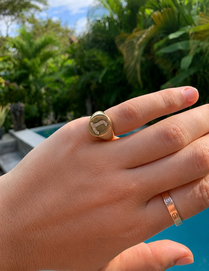 Lab-grown diamond initial signet ring with letter L set in yellow gold, shown on hand