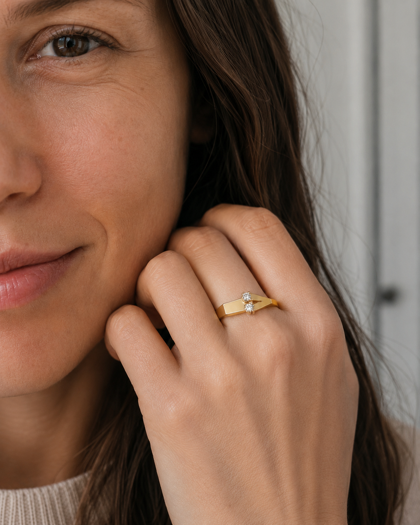Woman modeling the Different Love natural diamond ring in yellow gold beside her face.