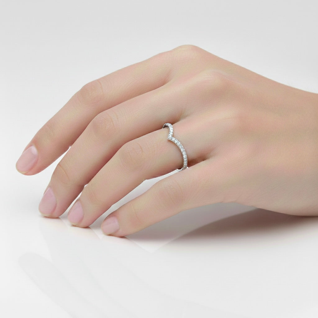 Side view of a three-stone lab-grown diamond engagement ring with round center diamond and tapered side stones on hand