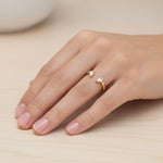 Load image into Gallery viewer, Open pair natural diamond ring shown on hand, front view with two pear-cut diamonds facing each other on a yellow gold band