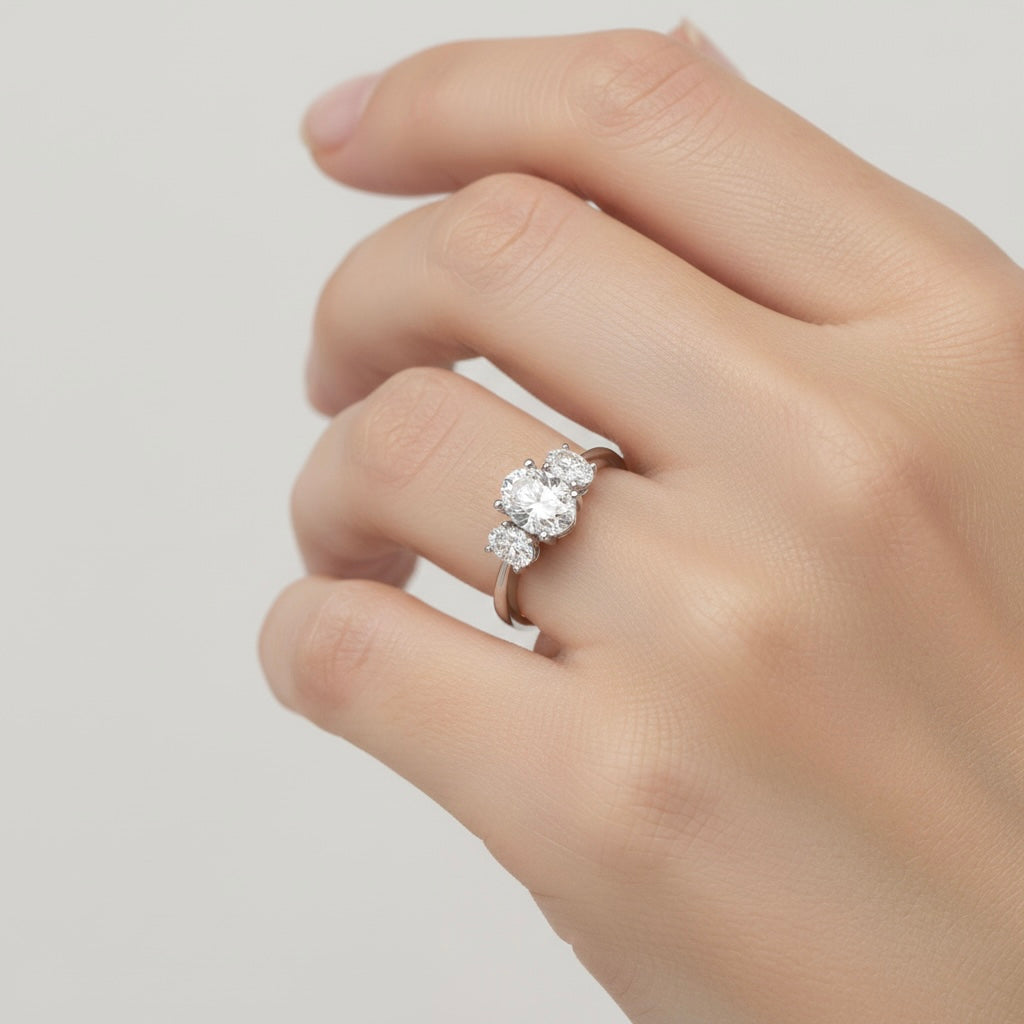 Lab-grown oval diamond three-stone engagement ring on hand