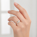 Load image into Gallery viewer, Three stone lab-grown diamond ring worn on hand with round center and pear side stones