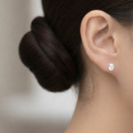 Load image into Gallery viewer, Oval cut lab grown diamond stud earring worn on ear in yellow gold, classic solitaire setting