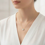 Load image into Gallery viewer, Woman wearing a round halo lab-grown diamond pendant necklace in yellow gold, front view on the neck