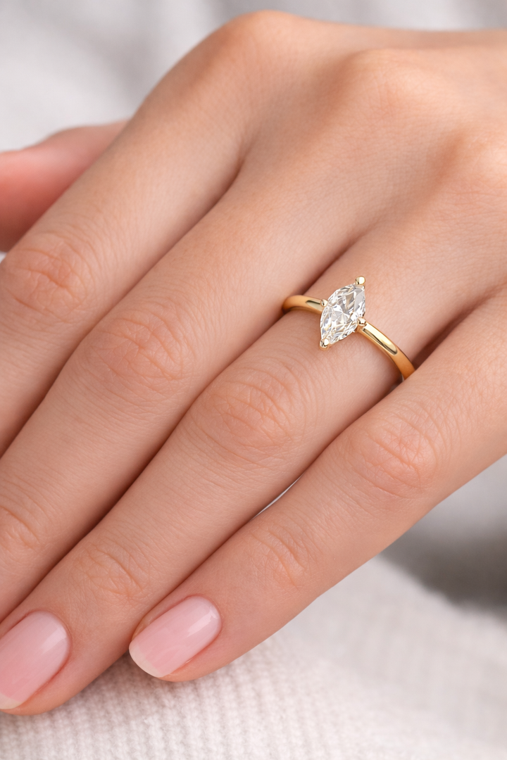 Marquise cut lab-grown diamond solitaire ring in yellow gold on a woman’s hand