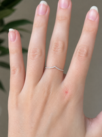 Load image into Gallery viewer, Close-up of a woman’s hand wearing a modern V-shaped lab-grown diamond ring with round diamonds in 14K white gold and a delicate pavé band.