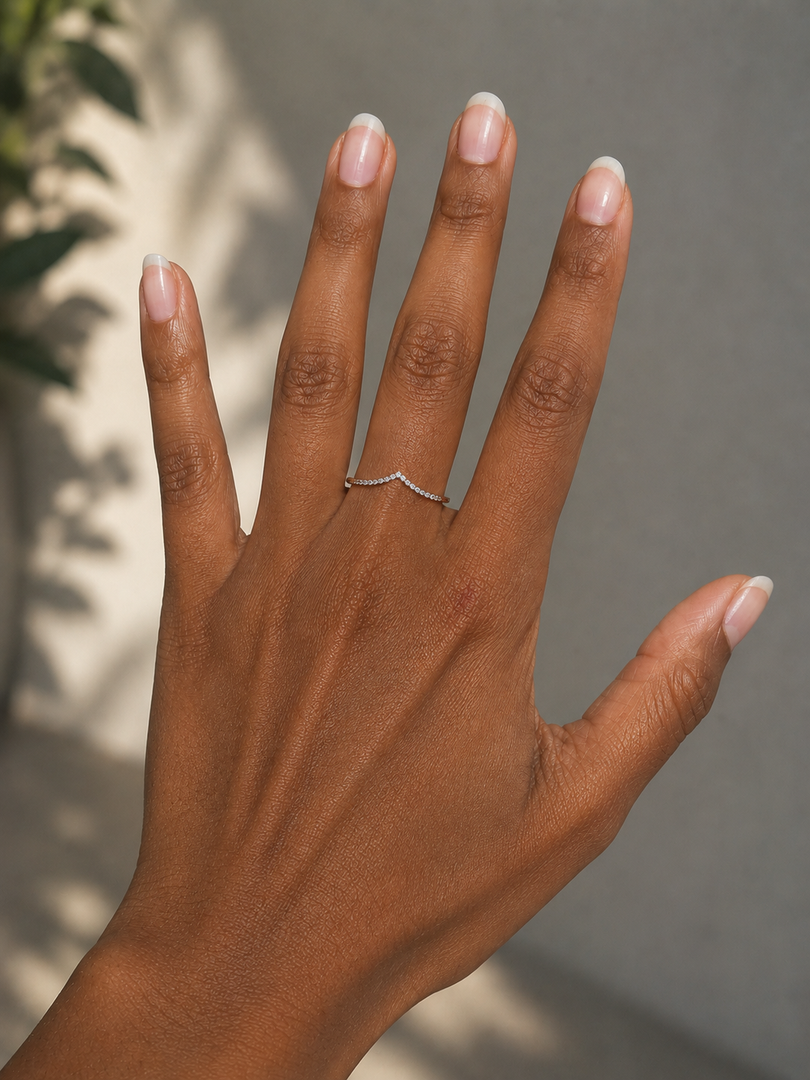 Elegant hand wearing a minimalist V-shaped natural diamond ring with round diamonds in 14K white gold, featuring a refined half-eternity design.