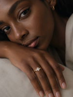 Load image into Gallery viewer, Close-Up of a Woman Wearing a Lab-Grown Oval Three-Stone Diamond Engagement Ring with Pear Side Stones in Yellow Gold