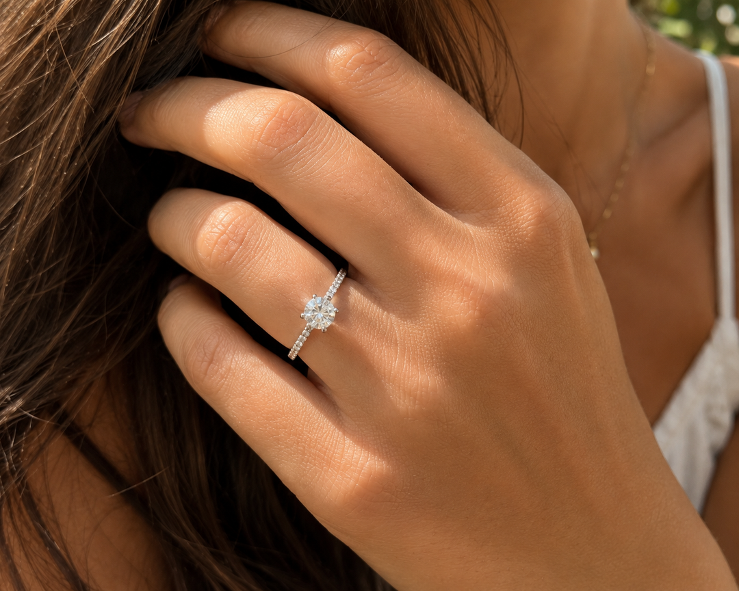 Round lab-grown diamond ring with side stones set in white gold, shown on a woman’s hand