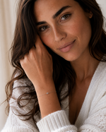 Load image into Gallery viewer, Woman wearing an emerald-cut lab-grown diamond bezel bracelet on her wrist.